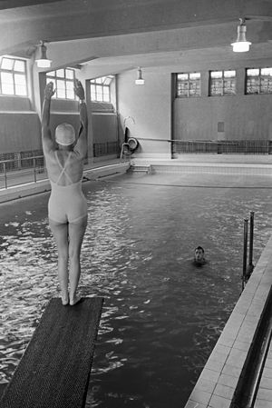 Young woman standing on the diving tower in a swimming pool, Freudenstadt, Germany 1930s (b/w photo)