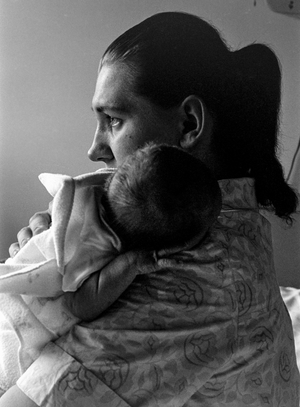 Woman burbs newborn baby after feeding in Palmer, Alaska, 1961 (photo)
