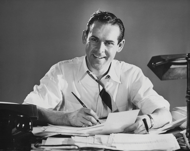 Businessman writing with a pen on documents and smiling