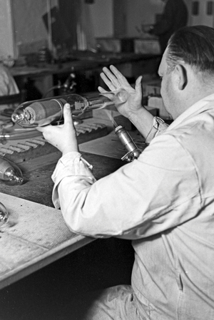 A staff member producing a fluorescent tube, Germany 1930s (b/w photo)