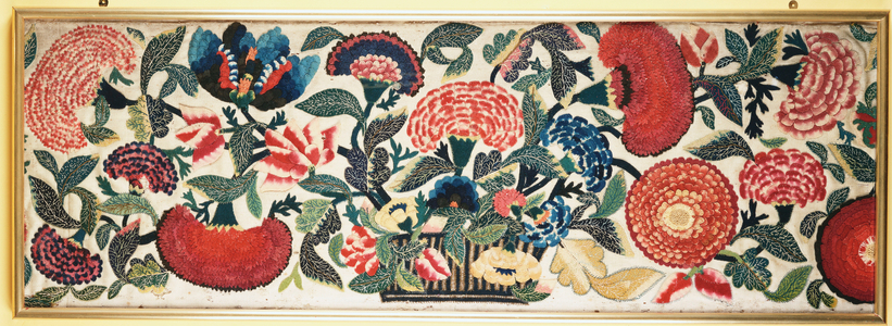 A felt and applique panel with embroidered silk highlights depicting carnations, tulips & other flowers overflowing from a basket against an ivory wool ground, c.1730-40 (felt, wool, silk)