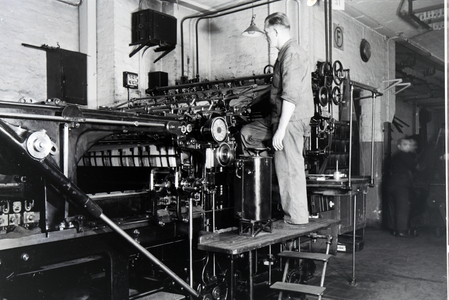 A worker controlling the rotary printing press in the plants of the mechanical engineering company MAN (Maschinenfabrik Augsburg-Nürnberg), Germany 1930s (b/w photo)