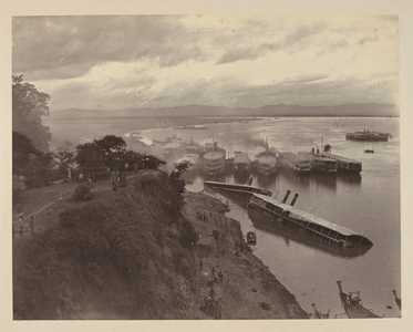 The fleet at Pagan... This place was reached by the Expedition on the 22nd November. The picture shows the fleet at anchor. In the foreground are two of King Theebaw's steamers half submerged, they having been scuttled and deserted on our approach
