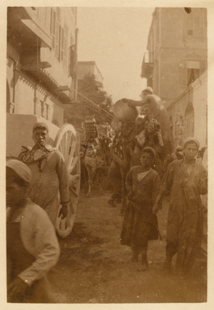 Egyptian people and camels on a busy city street, 1916 (b/w photo)