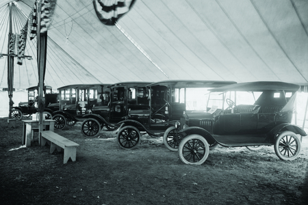 Automobiles on Display in Tent Under American Flag Banners 1921 (photo)