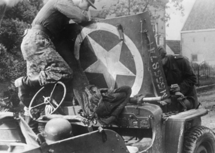 Soldiers of the Waffen-SS inspect a British jeep in Holland, 1944 (b/w photo)