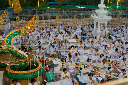 Buddhist worshippers in 'Sai Sin' ceremony at beginning of all-night puja outside Wat Meechai temple, Nong Khai, Isaan, Thailand (photo)