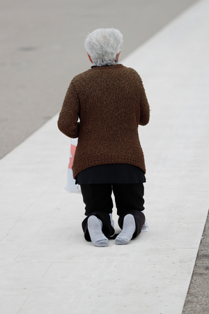 Sanctuary of Fatima. Rear view of worshipper crawling on his knees towards the Chapel of the Apparitions. Portugal.