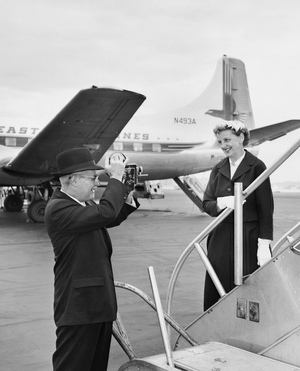 Senior man taking a picture of a senior woman at an airport