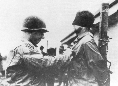 An American soldier blindfolds a soldier from Skorzeny's command, France, 1944 (b/w photo)