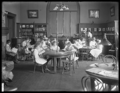 Children reading in the reading room of an unidentified branch of the Queens Borough Public Library, c.1910 (b/w photo)