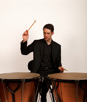 Timpanist playing two calf-headed Ringer style timpani.