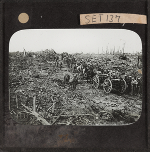 Horse-drawn ammunition limbers pass through the ruins of Longueval, September 1916 (lantern slide)