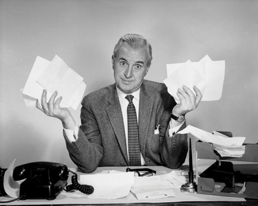 Businessman sitting at a desk and holding documents