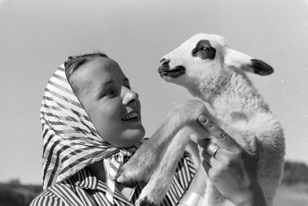 A young woman holding a spotted goat kid, St Märgen in the Southern Black Forest, Germany 1930s (b/w photo)