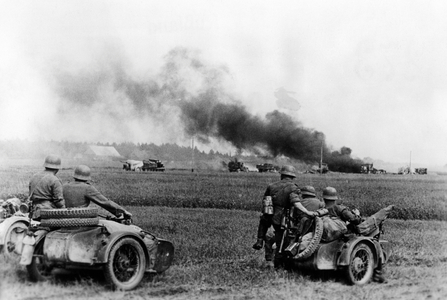 German motorcycle troops pass by burning Soviet vehicles, 1941 (b/w photo)