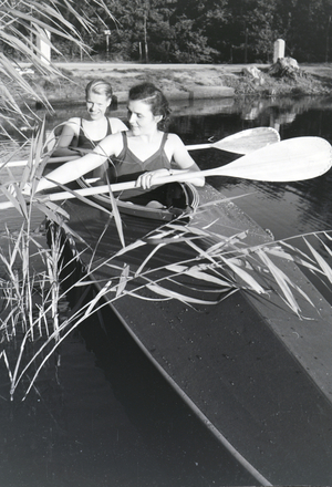 Young couple paddling in a boat on a lake near the river, Germany 1930s (b/w photo)