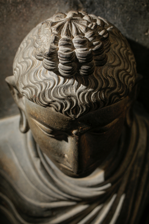 Detail of Schist stone Gandhara figure of Buddha wearing flowing robes with curls ris…, 2015 (photo)