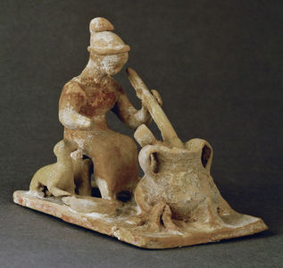 Cook on a stool, turning a ladle in a three-legged pot with two handles …