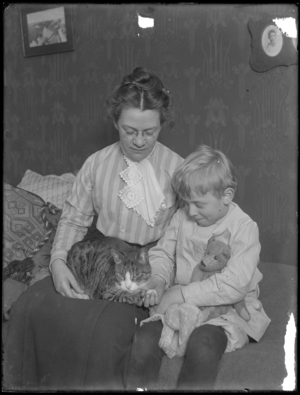 Harriet E. Hassler and William Gray Hassler, seated with tabby cat (Reddy) and teddy bear, c.1911 (b/w photo)