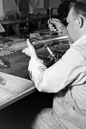 A staff member producing a fluorescent tube, Germany 1930s (b/w photo)