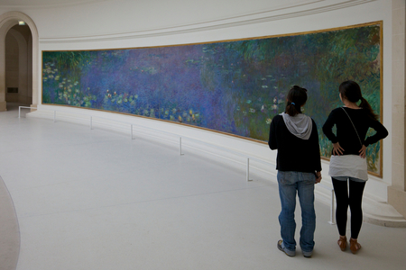 Two young women admire the Waterlilies by Claude Monet, Musée de l'Orangerie, Paris, France, Europe