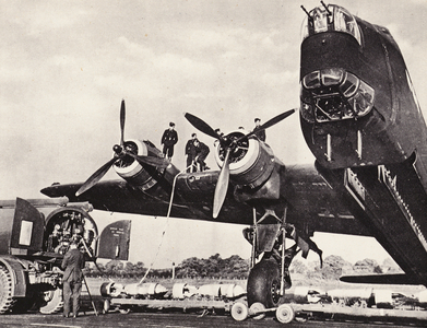 WW2: A Stirling is refuelled, her bomb-racks open ready for bombing-up (b/w photo)