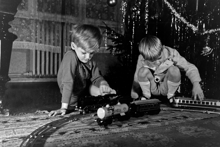 Two boys playing with the new model train under the christmas tree, Germany 1930s (b/w photo)