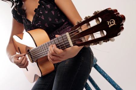 Young woman playing the acoustic guitar