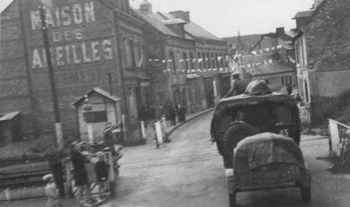 Military Vehicle travels through town, 1942 (b/w photo)