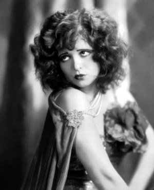 Circa 1929: Hollywood Film Star, Clara Bow (1905 - 1965) Poses In A Cape With Jewelled Clasp.