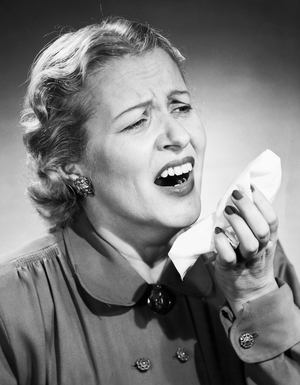 Close-up of a mid adult woman sneezing