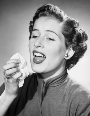 Close-up of a mid adult woman sneezing