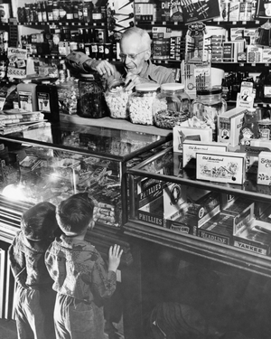 Rear view of two boys standing at a store counter