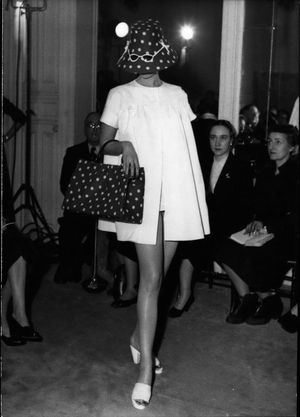 Jan. 28, 1954 - During a cocktail party last night, Jacques Fath presented accessories to preface his big collection. All the models wore black bodysuits, which gave the accessories an irresistible fantasy. The hat with sunglasses inlaid on the front and matching bag were a big success