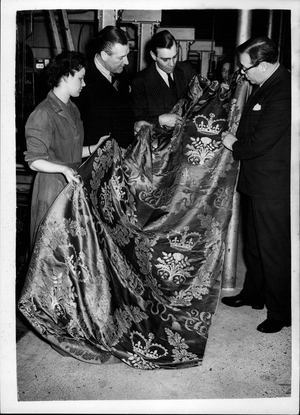 Tue 03, 1953 - Coronation Fabric for Balcony Frontals This Coronation fabric, called Queensway will be used for balcony frontals in Wesminster Abbey for the Coronation in June. It is of blue silk with the designs in gold. 1,700 yards of it are being made at a mill in Braintree, Essex, and it is seen here being inspected by the Minister of Works, Mr. Eccies (left)