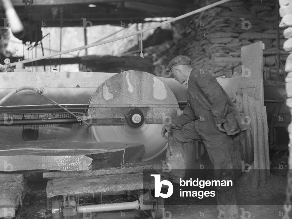 Man working circular saw and cutting rock, 1930s-60s (b/w photo)