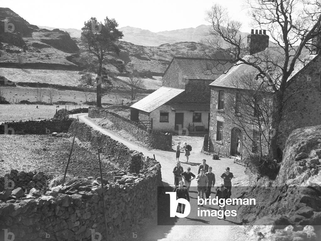 Walkers in a lane with farmhouse to the right of image, 1930s-60s (b/w photo)