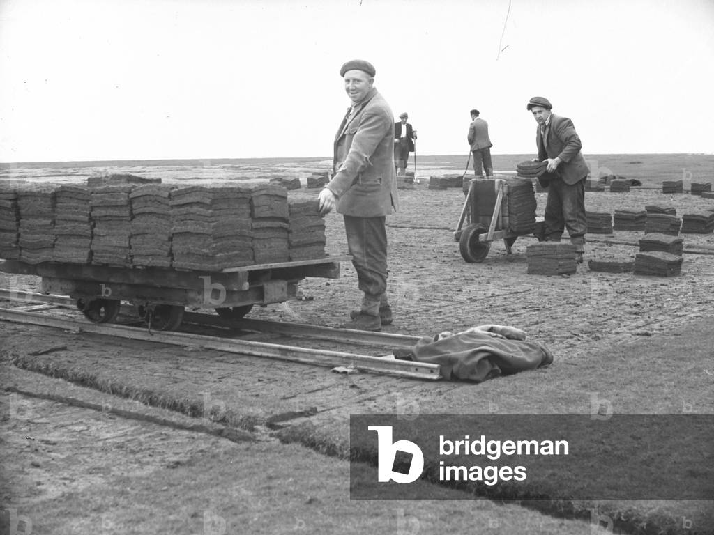 Stacks of turf loaded on to railway truck at Flookburgh, 1930s-60s (b/w photo)