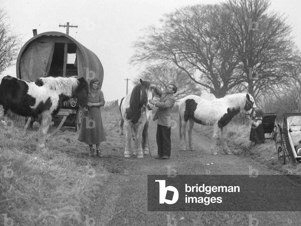 Hooped van on verge of road with gypsies and horses, 1930s-60s (b/w photo)