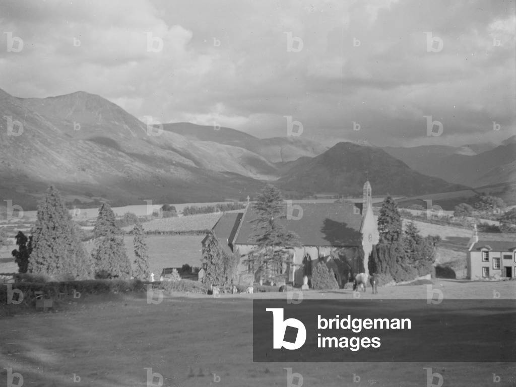 A view of a church; architecture; religious; ecclesiastical; surrounded by farmland and fells in the background, 1930s-60s (b/w photo)