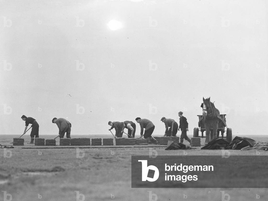 A group of men cutting turf or peat and putting it into piles, also aided by a horse and cart, 1930s-60s (b/w photo)