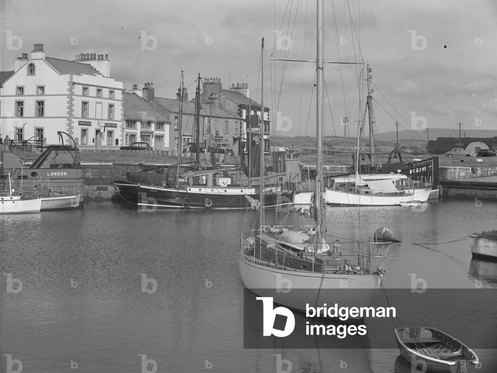 A range of different vessls moored in dock with buildings in the background, 1930s-60s (b/w photo)