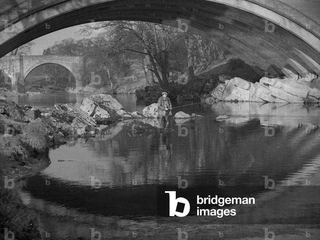 A man fishing in the middle of the river near to Devil's Bridge, 1930s-60s (b/w photo)