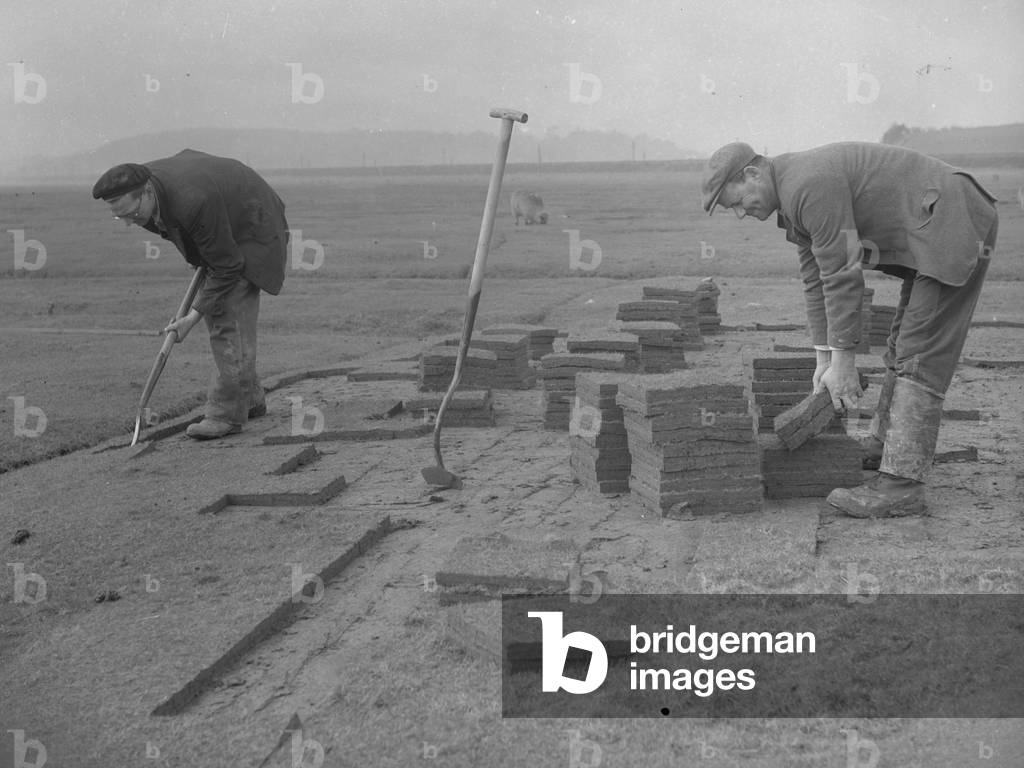 Two men cutting squares of turf using spades, 1930s-60s (b/w photo)