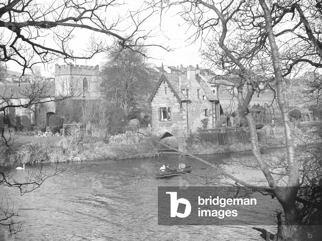 A view of some people in a rowing boat on the River Lune possibly fishing, in the background are buildings and a church; architecture; religious; ecclesiastical;, 1930s-60s (b/w photo)