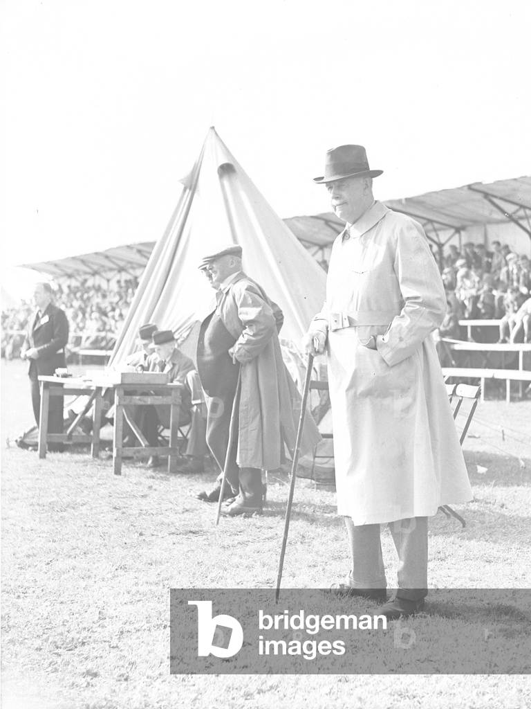 Lord Mostyn standing wearing hat and cane, 1930s-60s (b/w photo)