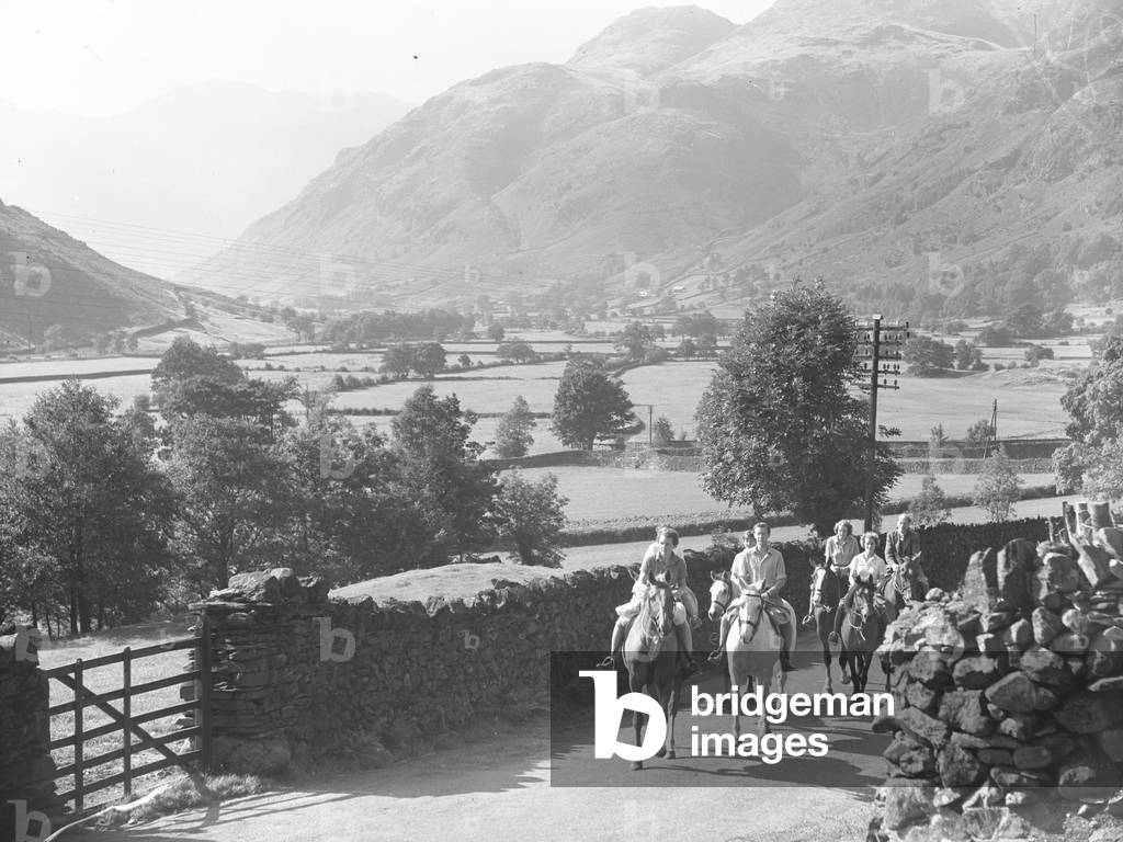 Riders on horseback on road in Langdale, 1930s-60s (b/w photo)