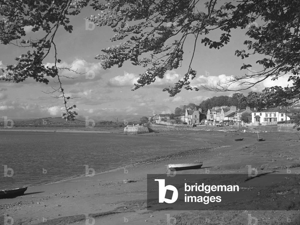 Boats beached on the shore of the Kent Estuary with Arnside and Compensation Pier and the viaduct behind, 1930s-60s (b/w photo)