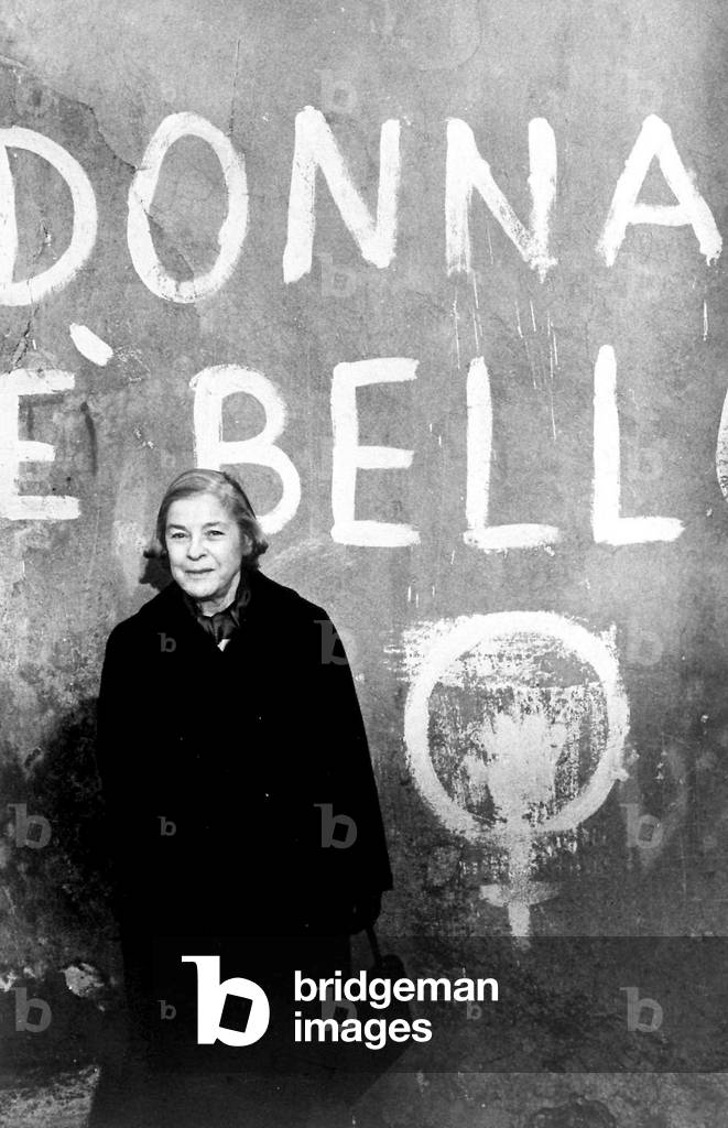 1981, portrait de l'ecrivain americaine Mary McCarthy (1912 - 1989) devant un slogan feministe dans une rue de Rome. Photo Frassinetti